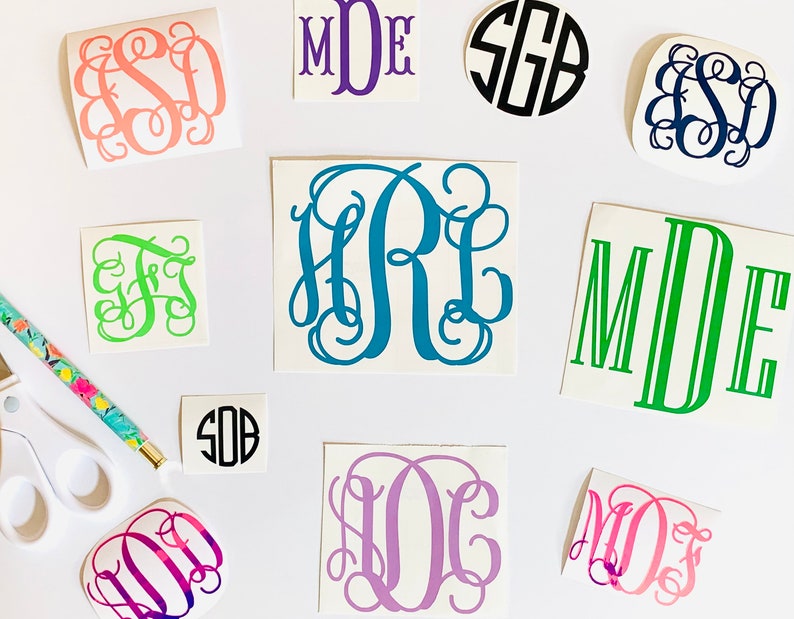 May include: Assortment of monogram decals in various colors and styles.  The decals feature different font styles and include the letters "MDE", "SEB", "FS", "HRL", "SOB", "LOC", "MOJ", and "MDE".