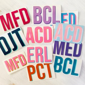 May include: Assortment of colorful stickers with letters spelling out the words "MFD", "DJT", "BCL", "ACD", "MED", "ERL", "PCT", and "ACD".