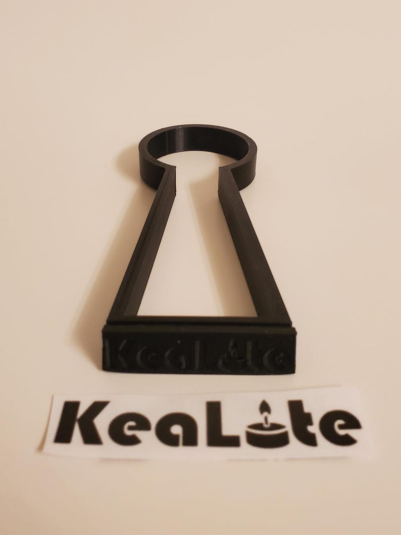 May include: Black plastic key-shaped candle holder with the text "KeaLte" on the bottom.