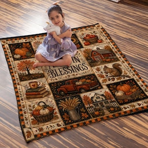 May include: A rectangular throw blanket featuring a patchwork design with autumn-themed illustrations including pumpkins, a red truck, a barn, a squirrel, and a basket of gourds, with the text "AUTUMN BLESSINGS" printed in the center of the blanket.