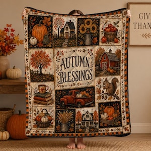 May include: A quilted throw blanket featuring a patchwork design with autumn-themed illustrations including pumpkins, a red truck, a squirrel, houses, and sunflowers. The center panel displays the text Autumn Blessings in a decorative script font.