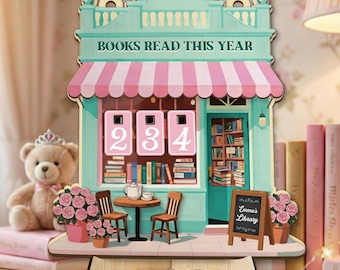 May include: A wooden bookstore-themed display with the text "BOOKS READ THIS YEAR" above three number counters displaying "234". The display features a pink and white striped awning, a small table, chairs, and a sign that reads "Emma's Library".