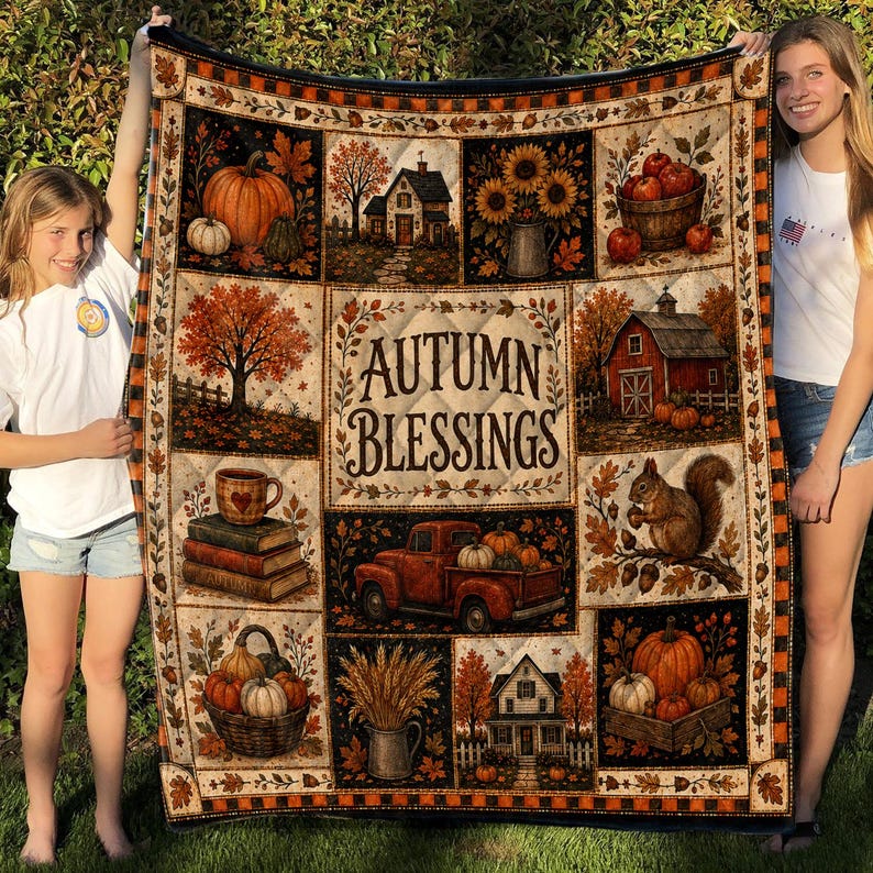 May include: A rectangular quilt featuring a patchwork design with autumn-themed illustrations including pumpkins, a red truck, a squirrel, houses, and sunflowers. The center panel displays the text Autumn Blessings in a decorative brown font.