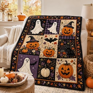 May include: A rectangular quilt featuring a patchwork design with Halloween motifs including white ghosts, orange jack-o'-lanterns, black cats, and bats. The pattern incorporates autumn leaves, purple plaid accents, and a black border with floral details.