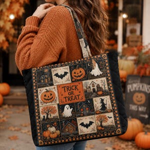 May include: A quilted tote bag featuring a grid of Halloween-themed illustrations including pumpkins, ghosts, bats, houses, and a witch. The central orange panel displays the text "TRICK OR TREAT" in black lettering. The bag has black side panels.