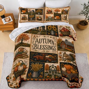 May include: A quilt and two pillowcases featuring a patchwork design with autumn-themed illustrations including pumpkins, a red truck, a barn, squirrels, and books. The central panel displays the text "AUTUMN BLESSINGS" in a dark brown font.