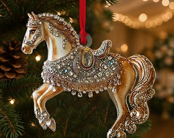 May include: A decorative horse ornament featuring a cream and gold finish with intricate crystal embellishments covering the saddle, bridle, and mane. The horse is in a prancing pose and is suspended by a thin red ribbon for hanging on a tree.