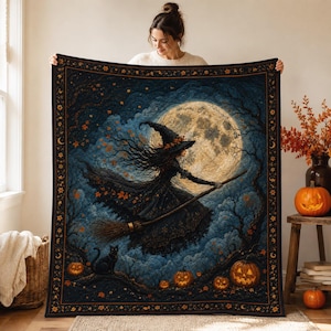 May include: A rectangular throw blanket featuring a dark blue night sky with a large full moon, a witch flying on a broomstick, a black cat, and several jack-o'-lanterns. The blanket has a decorative border with small orange leaf motifs.