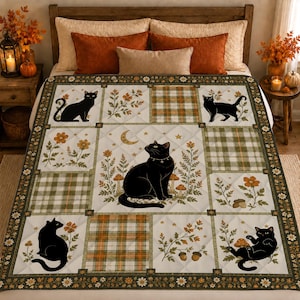 May include: A quilted bedspread featuring a patchwork design with alternating squares of black cats, autumn flowers, mushrooms, acorns, and green and orange plaid patterns. The central panel displays a large black cat with a crescent moon.