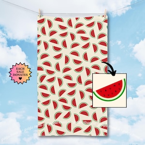 May include: A cream-colored towel with a pattern of red and green watermelon slices. A smaller image shows a watermelon slice with the text "TRUMP SUCKS". The towel is hanging on a clothesline against a blue sky.