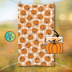 May include: A rectangular orange and white checkered towel with a repeating pattern of orange pumpkins. A smaller image shows an orange pumpkin with the words "buck trump". The towel is hanging on a clothesline.