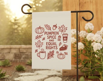 May include: A cream-colored garden flag with a black metal stand. The flag features a fall-themed design with pumpkins, leaves, and a coffee cup, along with the text "Pumpkin Spice and Equal Rights" in brown.