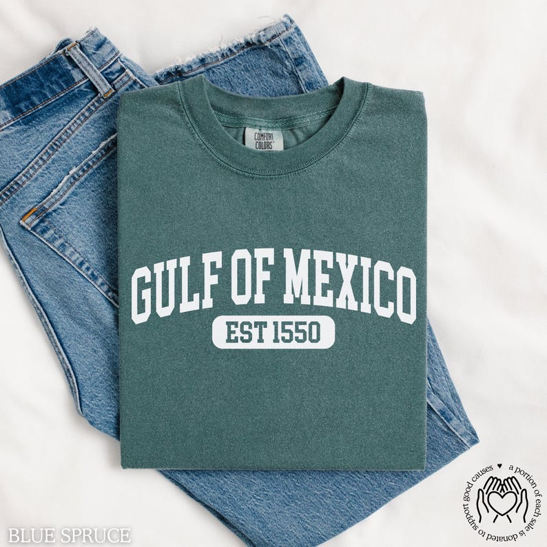 Puede incluir: Una camiseta azul turquesa con texto blanco que dice "GULF OF MEXICO EST 1550".