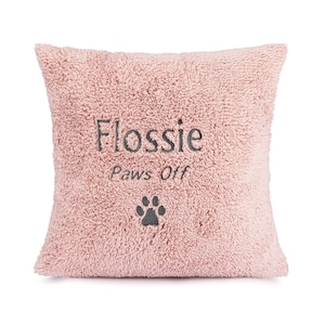 May include: Pink plush pillow with the text "Flossie paws off" and a paw print embroidered on it.