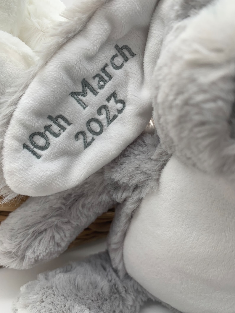 May include: A grey and white plush bunny with embroidered text that reads "10th March 2023".