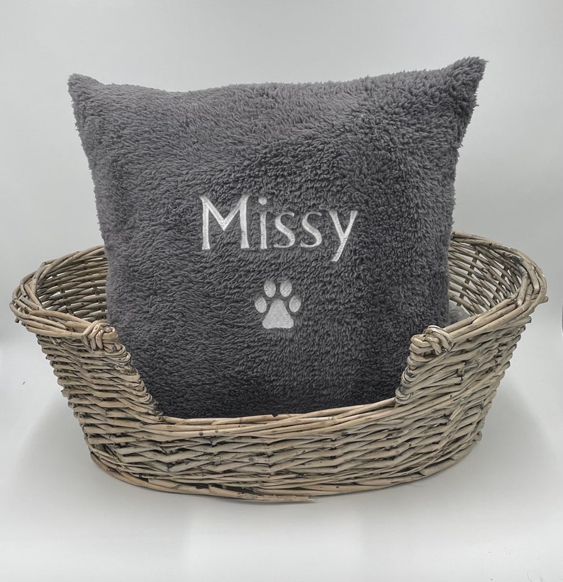 May include: Gray plush dog bed with a gray and white embroidered pillow that says "Missy" with a paw print.