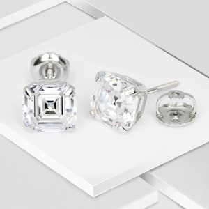 May include: A pair of silver stud earrings with clear square-shaped cubic zirconia stones.