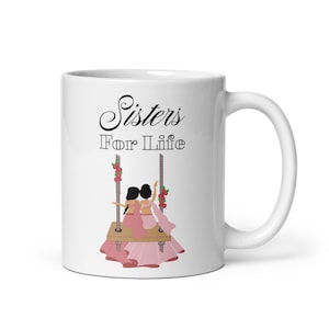 May include: White ceramic mug with a black and white graphic of two sisters on a swing. The text "Sisters For Life" is printed on the mug.