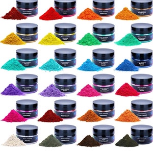 May include: A collection of 24 small jars of mica powder in various colors, including red, green, blue, purple, and gold. Each jar has a black lid and a label with the name of the color.