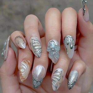 Presse papillon argent chromé sur ongles, accent nacré, faux ongles glam F1486