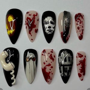 a collection of nail art designs featuring various patterns and colors, including blood splatters, skulls, and other spooky or gothic elements.