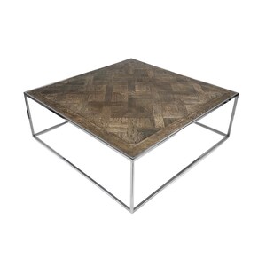 Peut inclure: Une table basse carrée avec un plateau en bois et un cadre en métal chromé. Le plateau a un motif parquet.