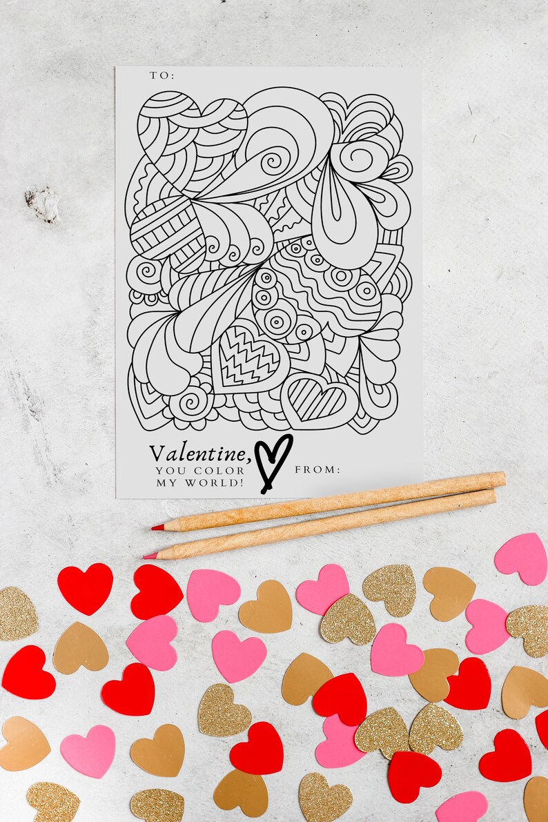 Image of a 4x6 valentine featuring a heart filled image for your valentine to color.  Valentine is primarily black and white. Image background is a heart confetti and colored pencils. By Titles and Jotters.