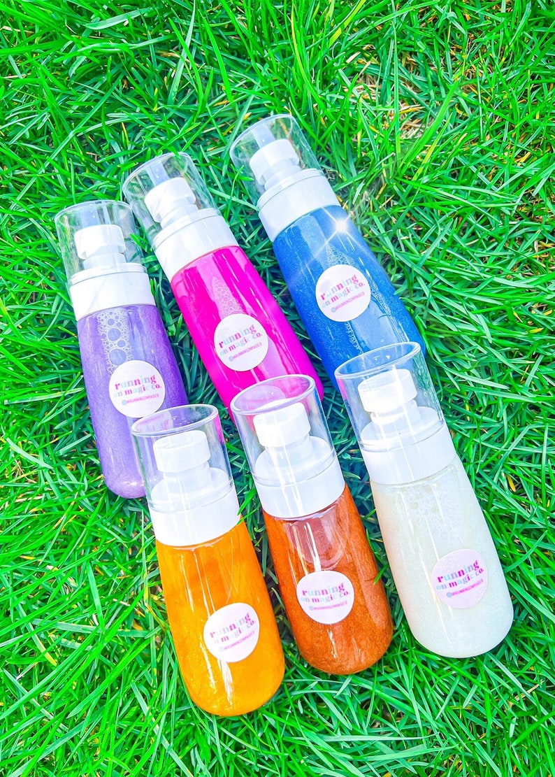 Peut inclure: Six flacons de spray scintillant pour le corps dans diff&eacute;rentes couleurs, notamment violet, rose, bleu, orange et or. Chaque flacon est dot&eacute; d'un bouchon pompe blanc et d'une &eacute;tiquette ronde avec le texte "running on magic co."