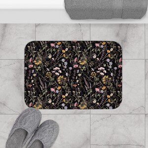 K&ouml;nnte beinhalten: Schwarze Badematte mit einem Blumenmuster mit verschiedenen bunten Blumen und Gr&uuml;n.