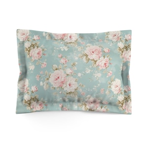 May include: A light blue pillowcase with a floral pattern featuring pink and white roses on a light blue background.