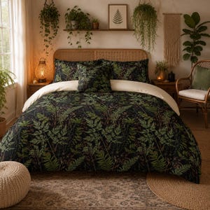 May include: A bedding set featuring a dark black background with a dense, repeating pattern of green fern leaves. The set includes a duvet cover and matching pillow shams, accented by a solid cream-colored top fold that contrasts with the dark botanical print.
