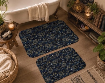 May include: Two rectangular bath mats featuring a dark blue background with a repeating celestial pattern of golden suns, crescent moons, and small stars. The mats have rounded corners and a soft, flat surface texture with a consistent print.