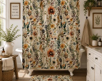 May include: A shower curtain and matching bath mat featuring a watercolor-style botanical print with orange, yellow, and muted green wildflowers, stems, and seed pods on a cream-colored background, suspended from a metal rod with rings.