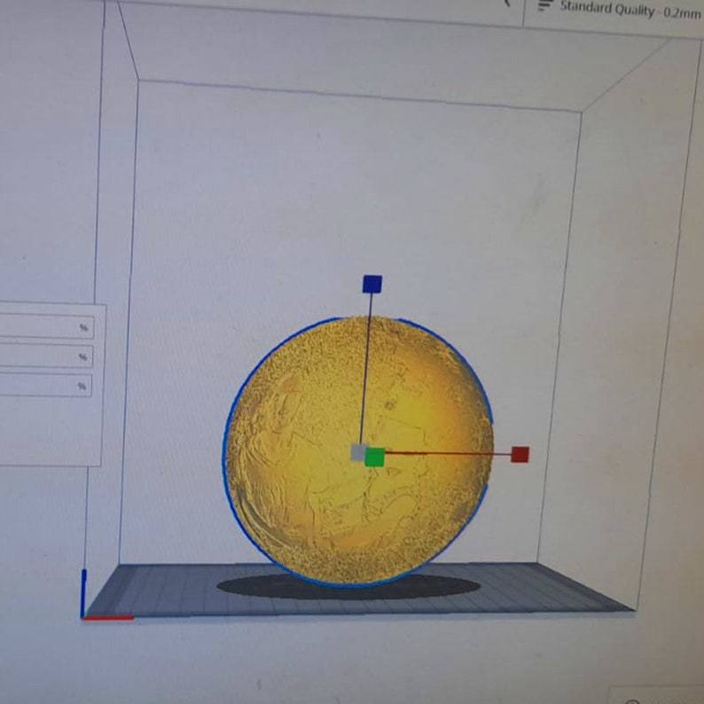May include: A 3D model of a sphere with a textured surface. The sphere is yellow with a blue outline. The model is positioned on a gray platform with a grid pattern. There are three red, green, and blue squares on the sphere.