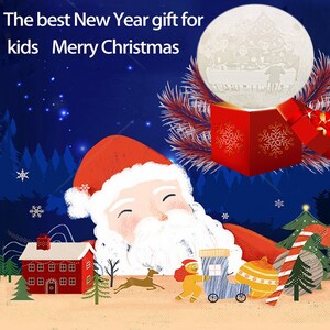 May include: A red and white Santa Claus with a white beard is sleeping in a snowy forest. A small gingerbread person is pulling a toy wagon with a yellow ornament. The text "The best New Year gift for kids Merry Christmas" is at the top of the image.