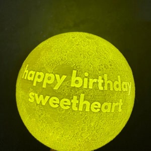 May include: A yellow moon lamp with the text "happy birthday sweetheart" engraved on the surface.