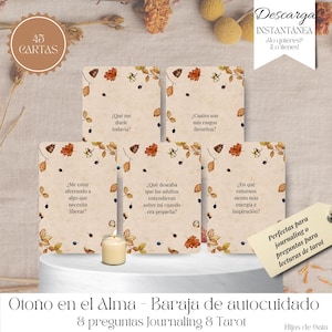 May include: A deck of 45 cards with autumn-themed illustrations and Spanish text. Each card features a question for journaling or tarot readings. The deck includes a small candle and a tag that reads "Perfect for journaling or tarot readings."