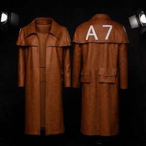 May include: A brown leather trench coat with a cape-like collar and two front pockets. The back of the coat has the white text "A7". The coat is displayed on a black background.