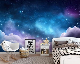 May include: A bedroom scene with a starry night sky mural. A white bed with a black and white patterned comforter is on the right. A white rocking chair and a side table with a star-shaped decoration are on the left. A framed print reads "exist to be happy not to press".