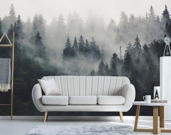May include: A white sofa with a light gray throw pillow sits in front of a wall mural depicting a misty forest. The forest is a dark green with a light gray fog.