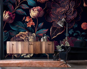 Può includere: Una carta da parati floreale scura con grandi fiori stilizzati nei toni del bordeaux, dell'oro e del verde acqua. Un mobile in legno con gambe in rame e una poltrona nera sono di fronte alla carta da parati.