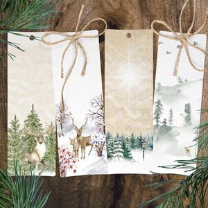 Pode incluir: Conjunto de quatro marcadores de página com tema de inverno, apresentando uma cena de floresta nevada, um veado em uma floresta nevada, uma floresta nevada com um poste de luz e uma cena de floresta neblinosa.