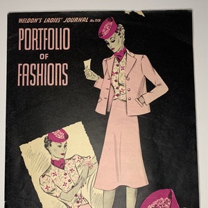 May include: A vintage magazine cover featuring a pink suit with a matching hat and a floral print blouse. The cover text reads "Portfolio of Fashions" and "Free Inside: Patterns of Smart New Outfit Swing Suit, Waistcoat Blouse and Gay Flowered Hat".