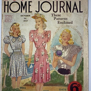 以下が含まれることがあります： 1947年10月号のオーストラリア・ホーム・ジャーナルのヴィンテージ雑誌の表紙。表紙には、ドレスを着た3人の女性と6dの価格が掲載されています。表紙の上部には「Don't Catch the Work-Shy Fever」というテキストが書かれています。右上隅には「These Patterns Enclosed」というテキストが書かれています。