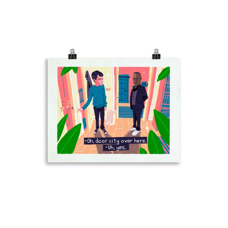 May include: A framed art print showing an illustration of two men in a hallway. One man gestures towards a door, while the other stands nearby. Text on the print reads "-Oh, door city over here. -Uh, yes."