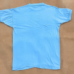 K&ouml;nnte beinhalten: Ein hellblaues T-Shirt mit geripptem Rundhalsausschnitt und kurzen &Auml;rmeln.