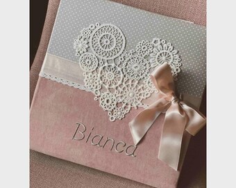 May include: A pink velvet scrapbook with a grey and white lace heart design and the name "Bianca" embroidered on the front.
