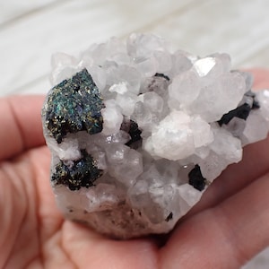May include: A cluster of white quartz crystals with iridescent black and green pyrite crystals.