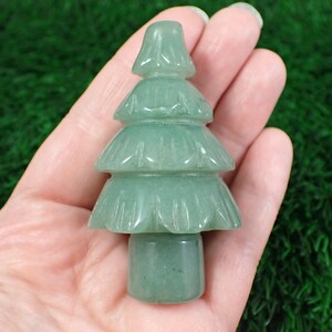 Op de afbeelding: Een groene jade gesneden kerstboom ornament. De boom is driedimensionaal en heeft een gladde, gepolijste afwerking.
