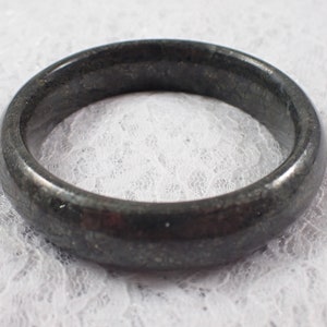 May include: A black jade bangle bracelet with a smooth, polished finish.